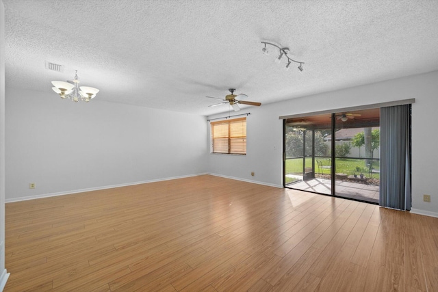 unfurnished room featuring ceiling fan with notable chandelier, a textured ceiling, and light hardwood / wood-style flooring