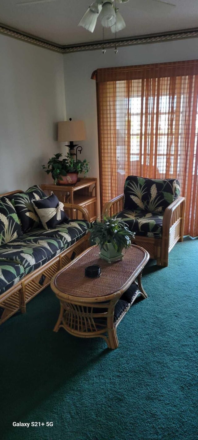 carpeted living room featuring crown molding and ceiling fan