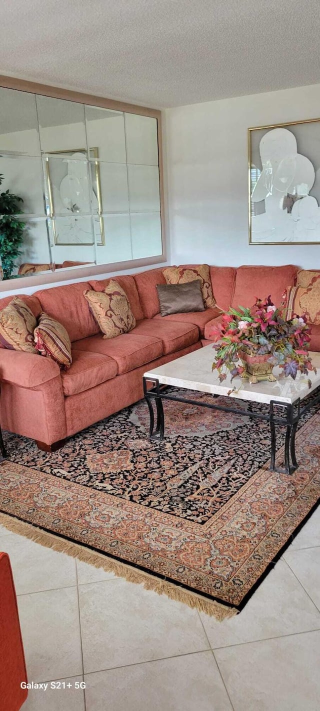 tiled living room featuring a textured ceiling