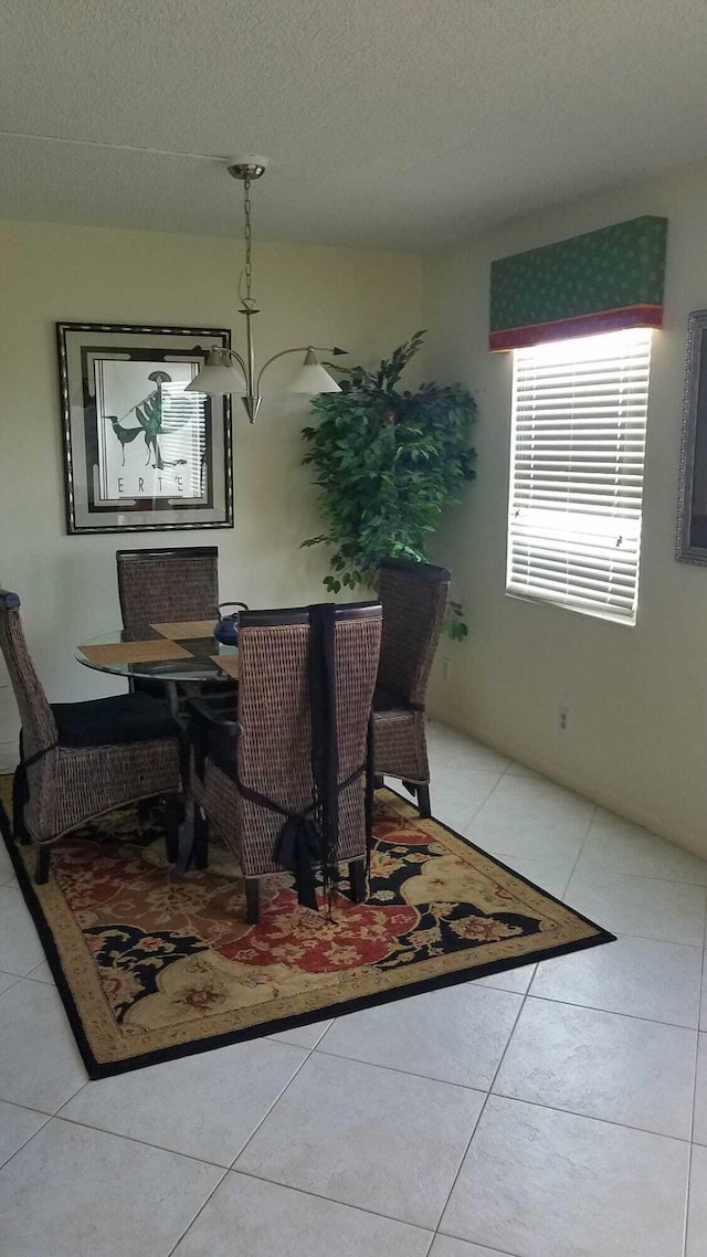 tiled dining space with a textured ceiling