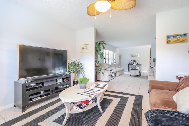 living room with light tile patterned flooring, ceiling fan, and a textured ceiling