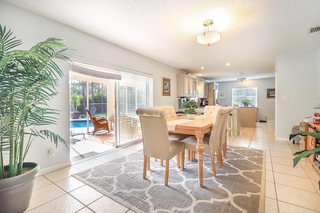 tiled dining room featuring a textured ceiling