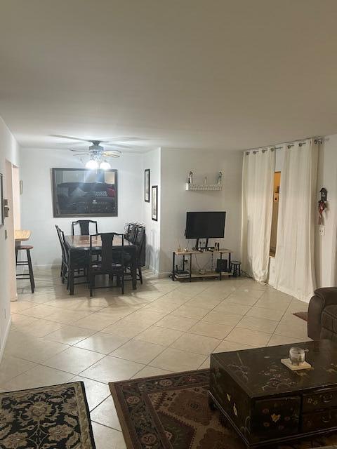 living room featuring light tile patterned floors and ceiling fan