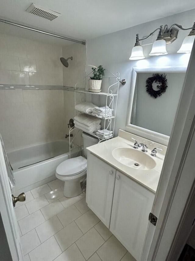 full bathroom featuring tiled shower / bath, vanity, tile patterned floors, and toilet