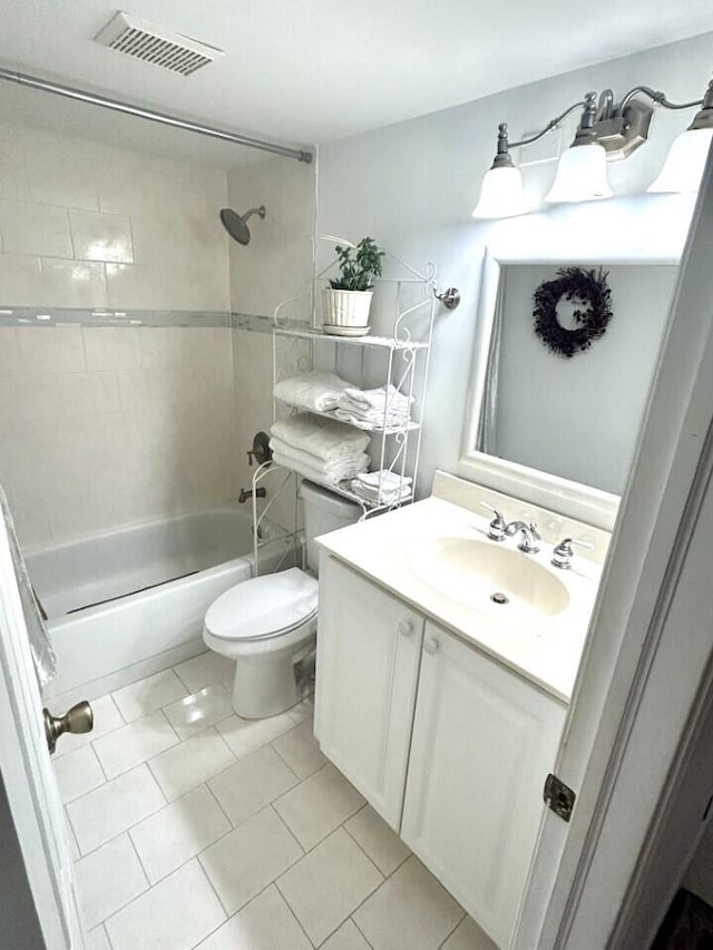 full bathroom featuring vanity, tile patterned flooring, toilet, and tiled shower / bath