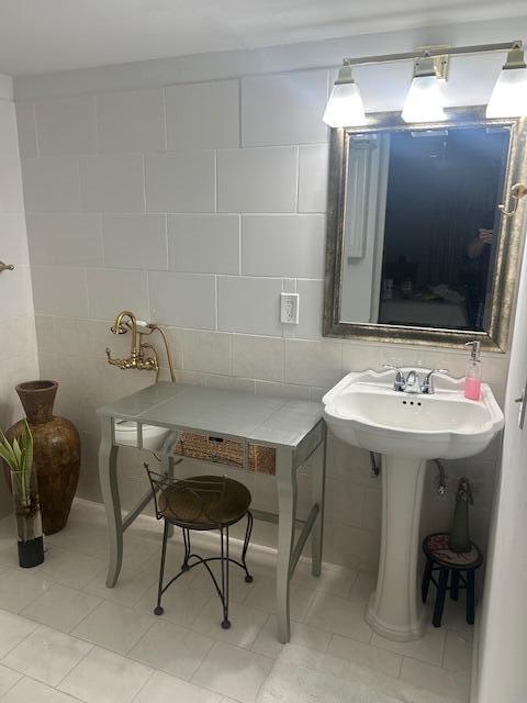 bathroom with tile patterned floors and tile walls