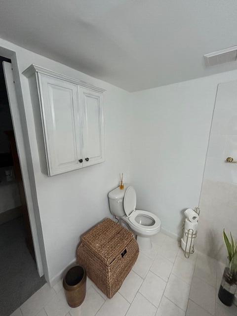 bathroom featuring toilet and tile patterned flooring