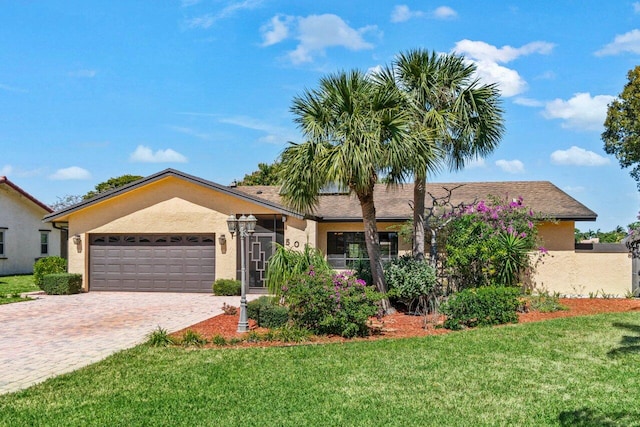 ranch-style home with a front lawn, decorative driveway, a garage, and stucco siding