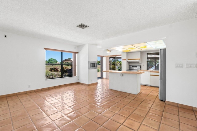 kitchen with visible vents, under cabinet range hood, light countertops, white cabinets, and stainless steel appliances