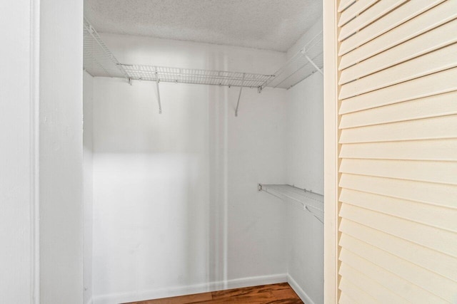 walk in closet with wood finished floors