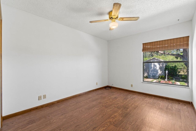 spare room with a ceiling fan, wood finished floors, baseboards, and a textured ceiling