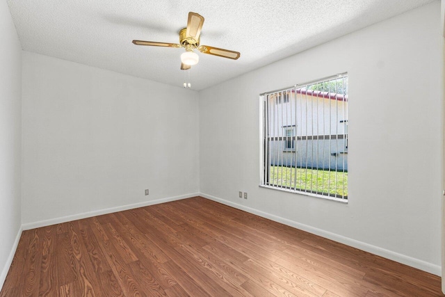 empty room featuring wood finished floors, a healthy amount of sunlight, and baseboards