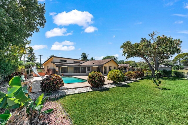 pool with a patio, a yard, and a sunroom