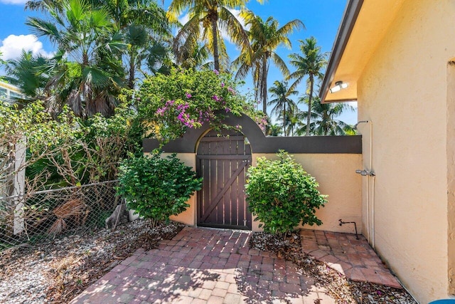 view of patio featuring fence and a gate