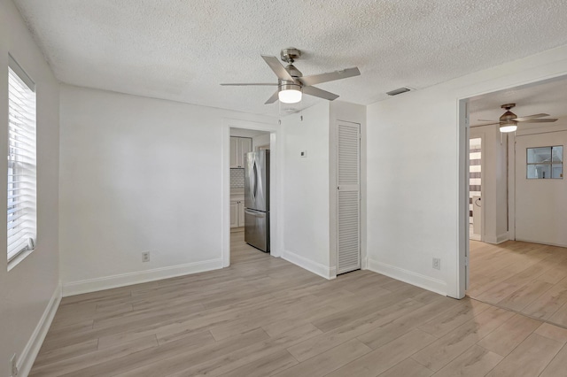 empty room with ceiling fan and light wood-type flooring