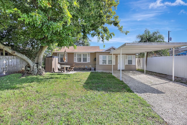 view of front of property with a carport and a front lawn