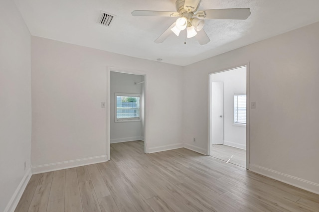 spare room featuring ceiling fan, plenty of natural light, and light wood-type flooring