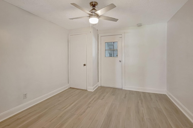 unfurnished room featuring ceiling fan, light hardwood / wood-style flooring, and a textured ceiling