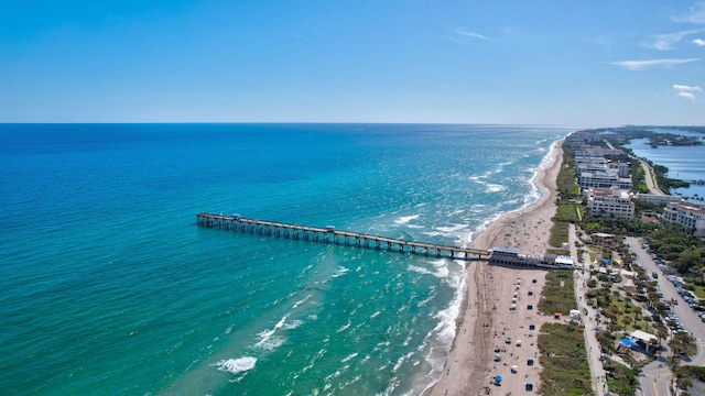 drone / aerial view with a water view and a beach view