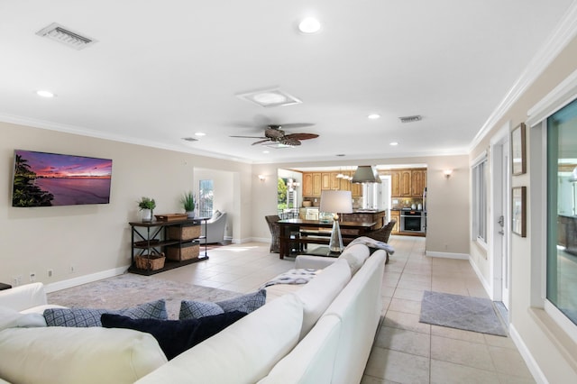 tiled living room with ceiling fan and ornamental molding