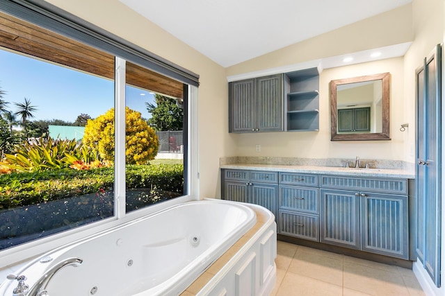 bathroom with lofted ceiling, tile patterned floors, vanity, and a washtub