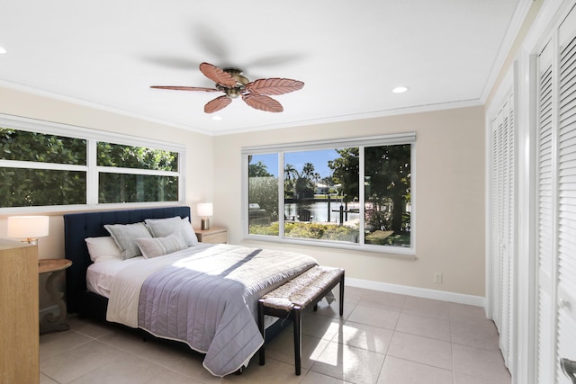 bedroom featuring light tile patterned floors, crown molding, ceiling fan, and a water view