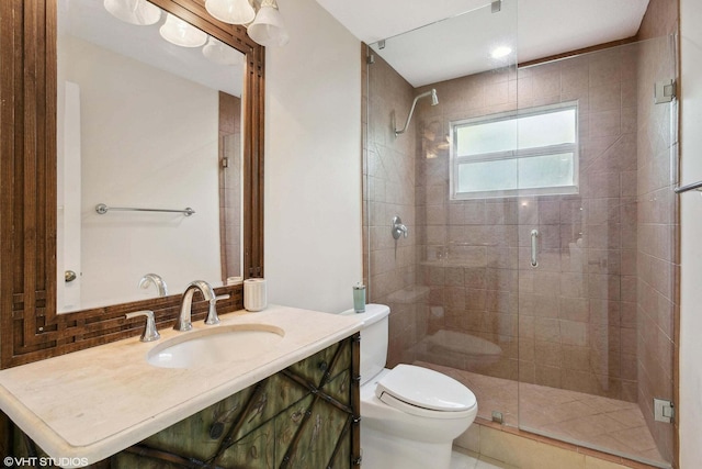 bathroom with toilet, vanity, and a shower with shower door