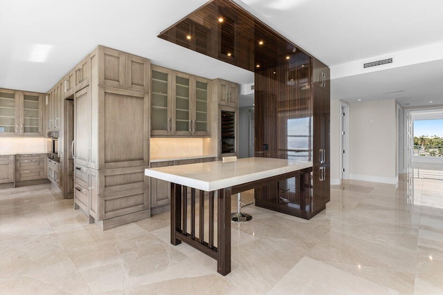 kitchen featuring light countertops, glass insert cabinets, oven, and visible vents