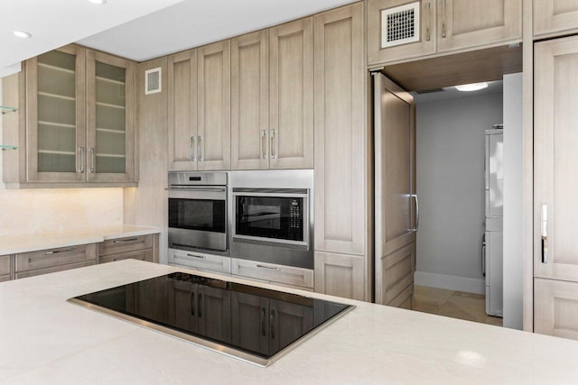 kitchen featuring visible vents, light countertops, black electric stovetop, and stainless steel oven