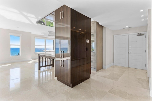 corridor featuring marble finish floor, recessed lighting, and baseboards