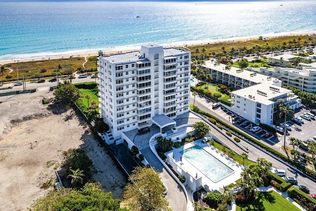 birds eye view of property with a water view and a beach view