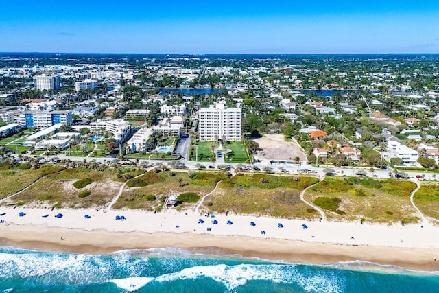 drone / aerial view featuring a view of city, a beach view, and a water view