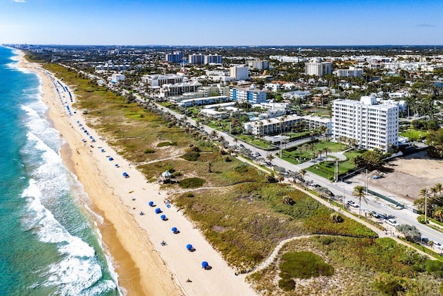 drone / aerial view with a water view, a view of the beach, and a city view