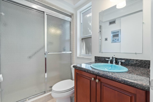 bathroom featuring vanity, toilet, and a shower with door