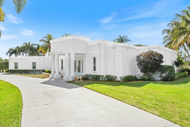 view of front facade with a front lawn and french doors