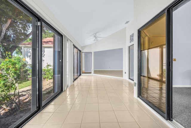 corridor featuring lofted ceiling and light tile patterned flooring