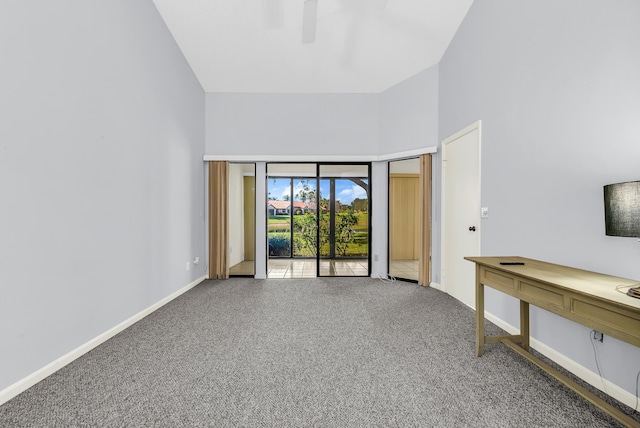 carpeted spare room featuring a high ceiling