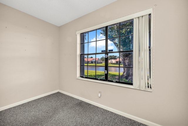 unfurnished room with a water view and carpet