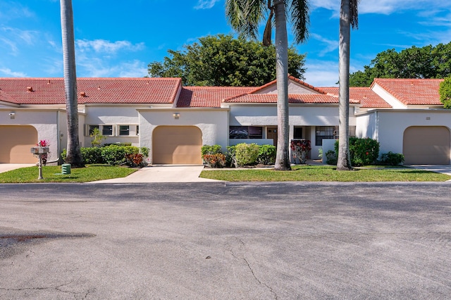 mediterranean / spanish house with a garage and a front lawn