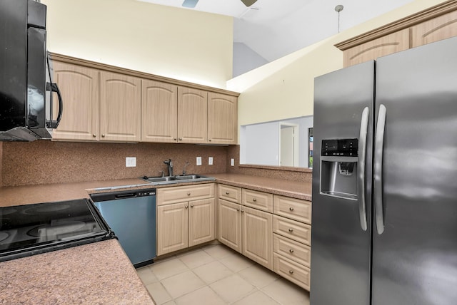 kitchen featuring lofted ceiling, stainless steel appliances, light brown cabinetry, and sink