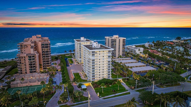 aerial view at dusk featuring a water view