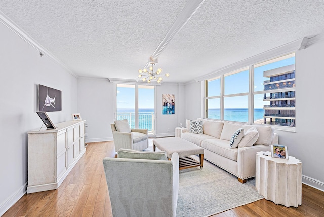 living room featuring a wealth of natural light, light hardwood / wood-style flooring, ornamental molding, and a water view