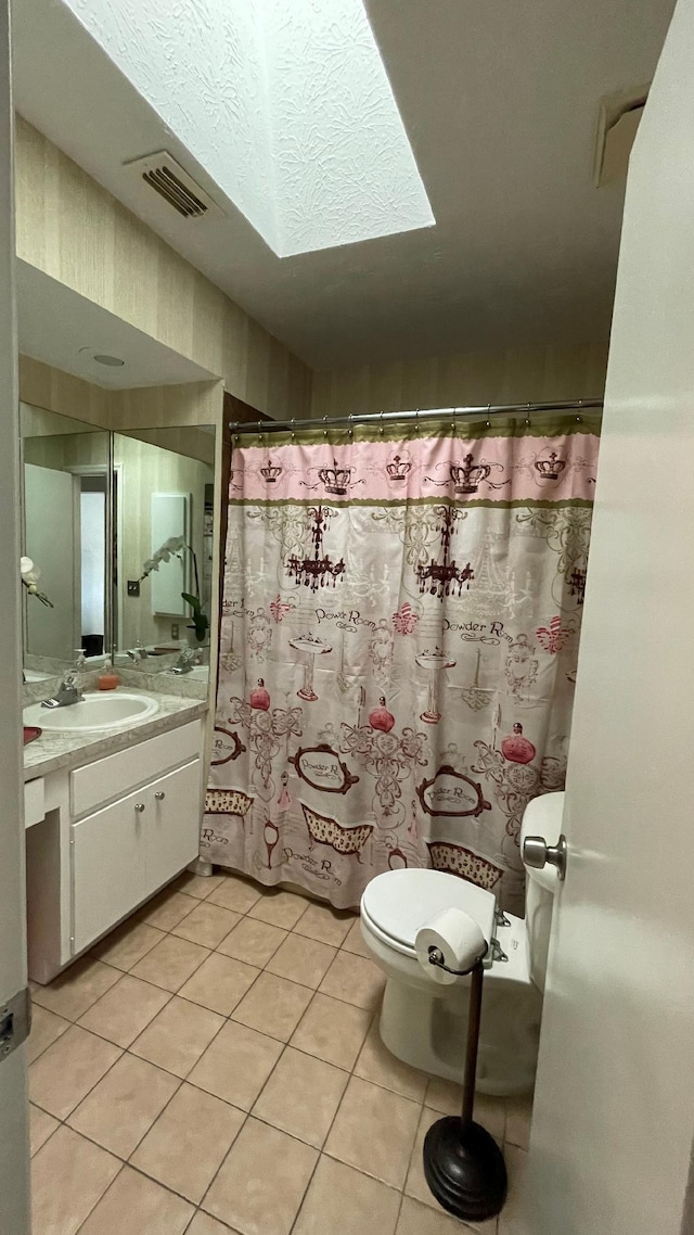 bathroom featuring tile patterned flooring, vanity, a textured ceiling, and toilet