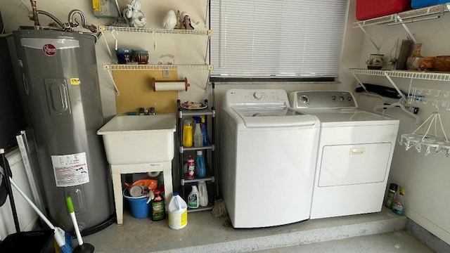 washroom with sink, washing machine and dryer, and water heater