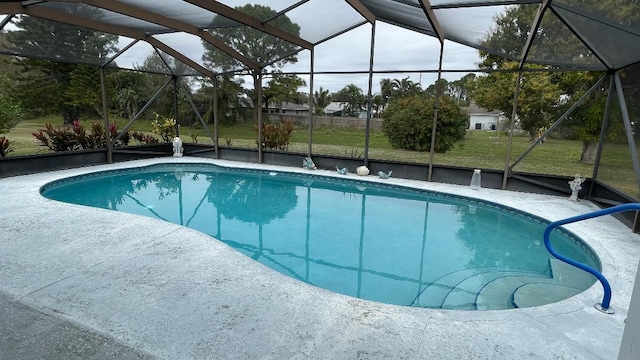 view of pool with a yard and glass enclosure