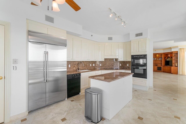 kitchen with a kitchen island, sink, dark stone countertops, decorative backsplash, and black appliances