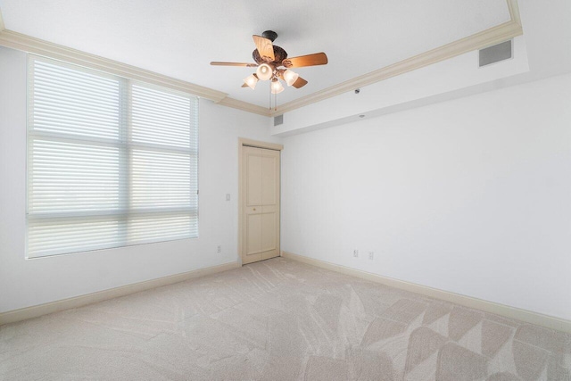 empty room featuring crown molding, light colored carpet, and ceiling fan