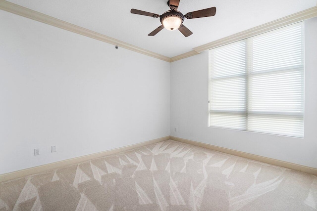 carpeted spare room featuring crown molding and ceiling fan