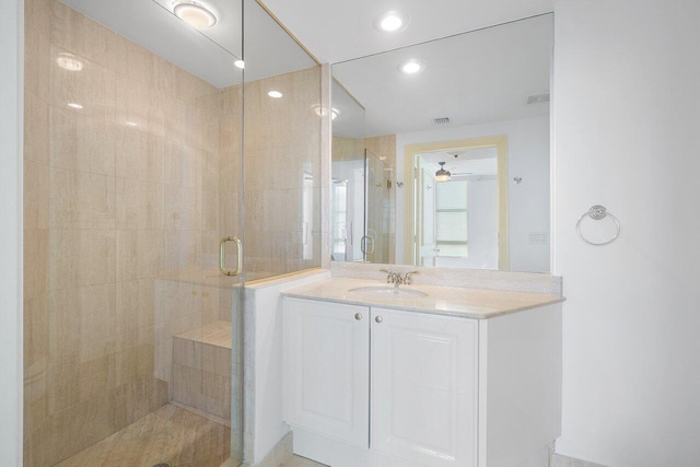 bathroom with vanity, a shower with shower door, and ceiling fan