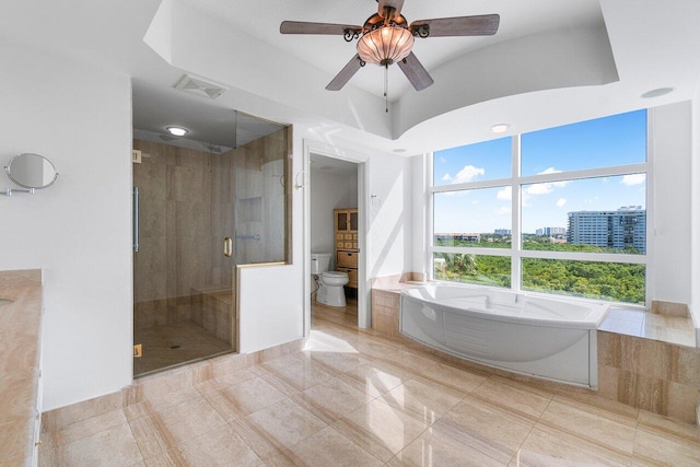 bathroom with plus walk in shower, ceiling fan, and toilet